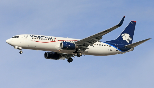 An Aeromexico Boeing 737-800 passenger jet in flight with landing gear undercarriage and flaps down extended