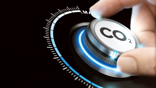 A visualisation of a dial labelled CO2 being turned down by a hand