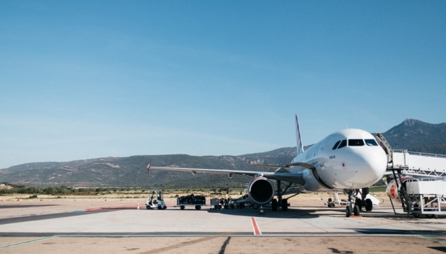 A commercial airliner Airbus A320 on the ground at an airport with a mountain in the background.