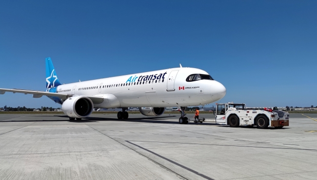 AN Air Transat Airbus A321neo aircraft on the ground at an airport with a blue sky in the background