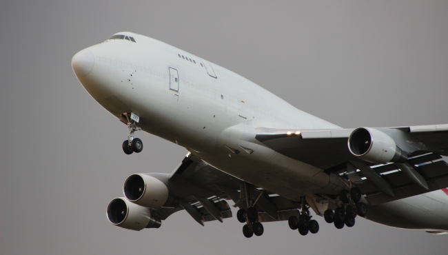 A boeing 747-400 freighter aircraft on takeoff with a grey sky behind