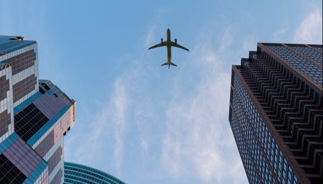 image of an aeroplane flying above buildings