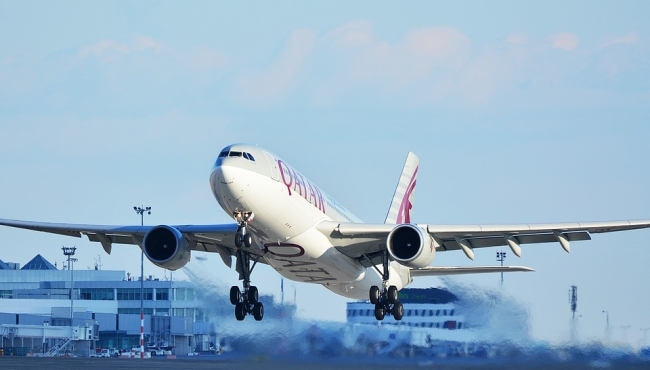 A Qatar Airways Airbus A330 jet passenger aircraft on take off with landing gear down.