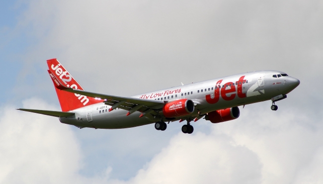 A Jet2 Boeing 737-800 in flight with landing gear and flaps extended