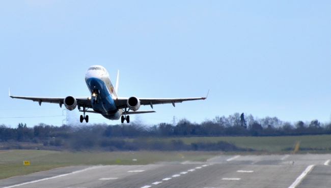 An embraer aircraft taking off from a runway
